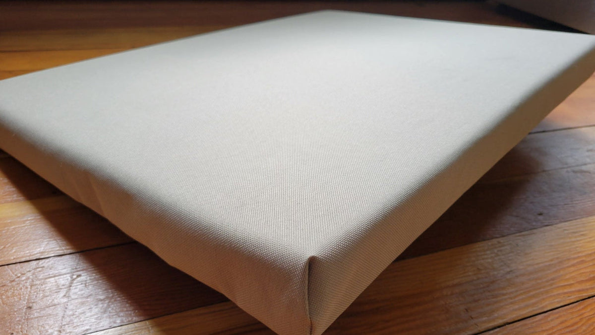 Beige custom waterproof dog bed by Room to Run on a wooden floor